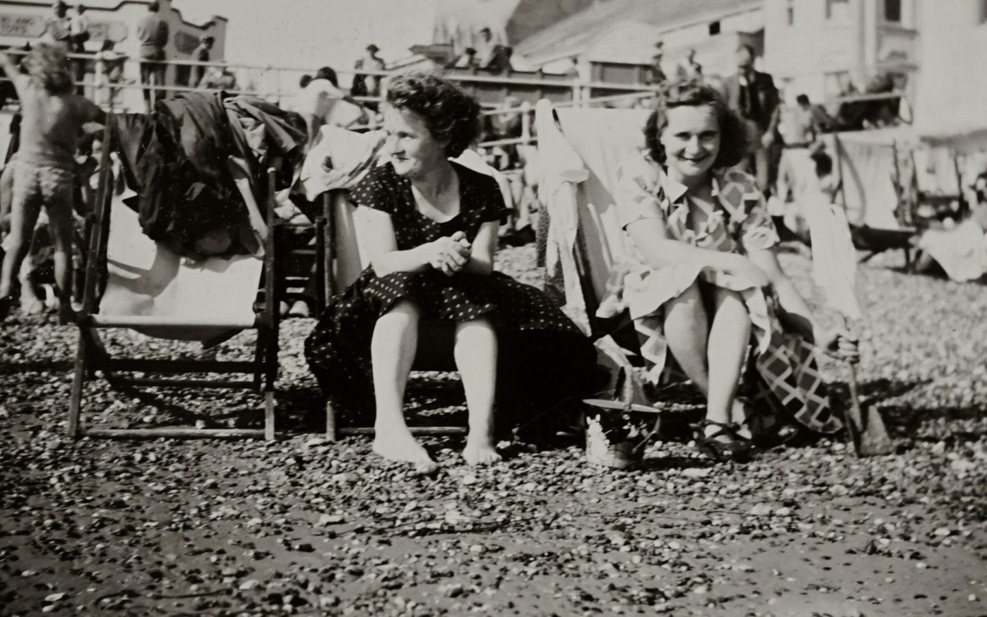 pexels-photo-5386860-5386860 Black and white vintage photo of women sitting on beach chairs in a lively setting.