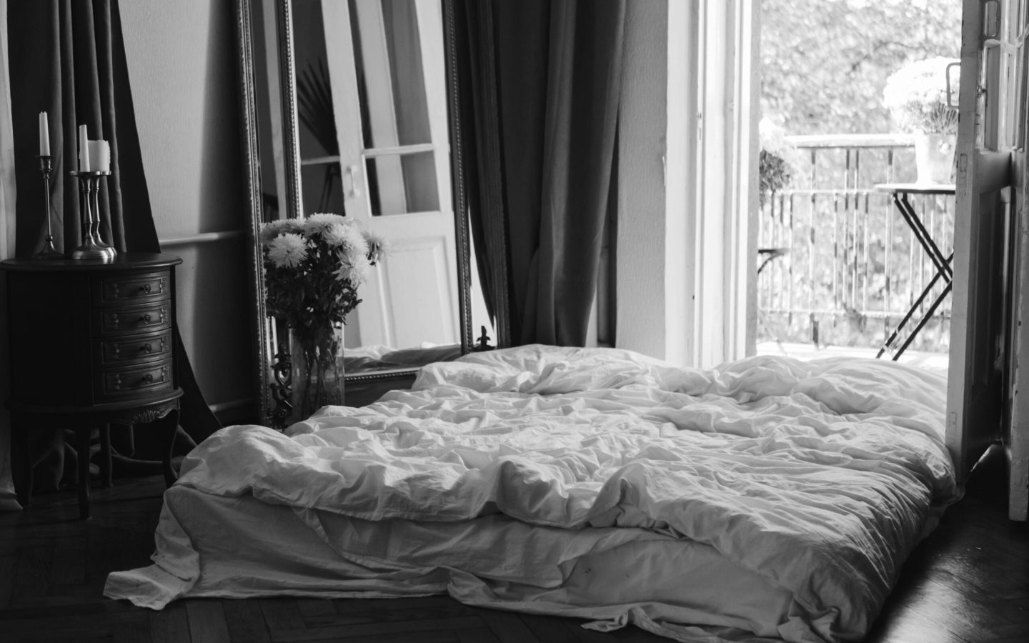 pexels-photo-5644708-5644708 Black and white image of a stylish bedroom with a balcony view, cozy bed, and elegant decor.